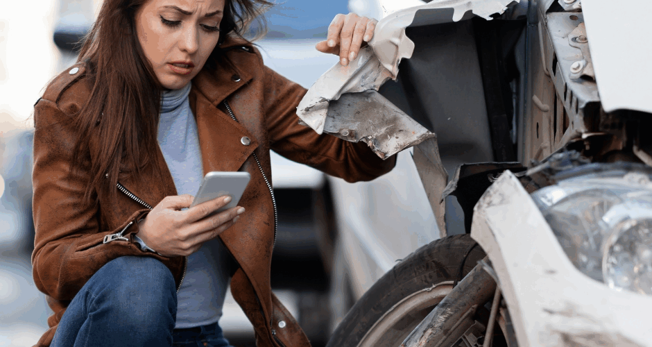 Woman dialing 911 after car accident