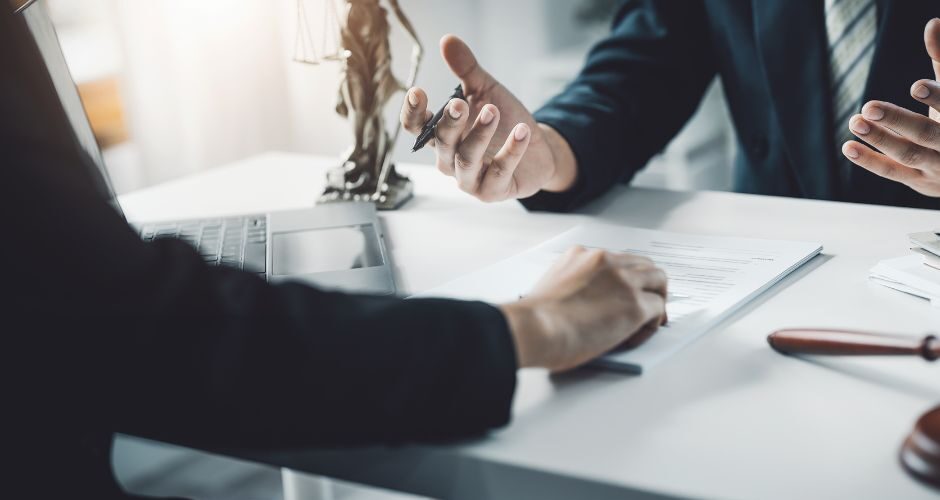 Attorneys seated at a desk.