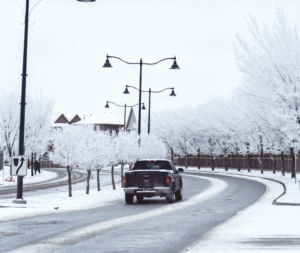 Chevy truck driving on icy roads as surrounding trees are covered with snow