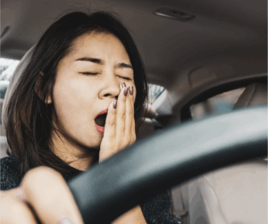 Woman yawning while at the wheel of a vehicle
