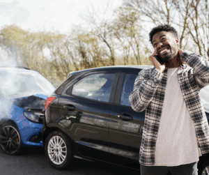 young man in an accident holding his neck while talking on the phone